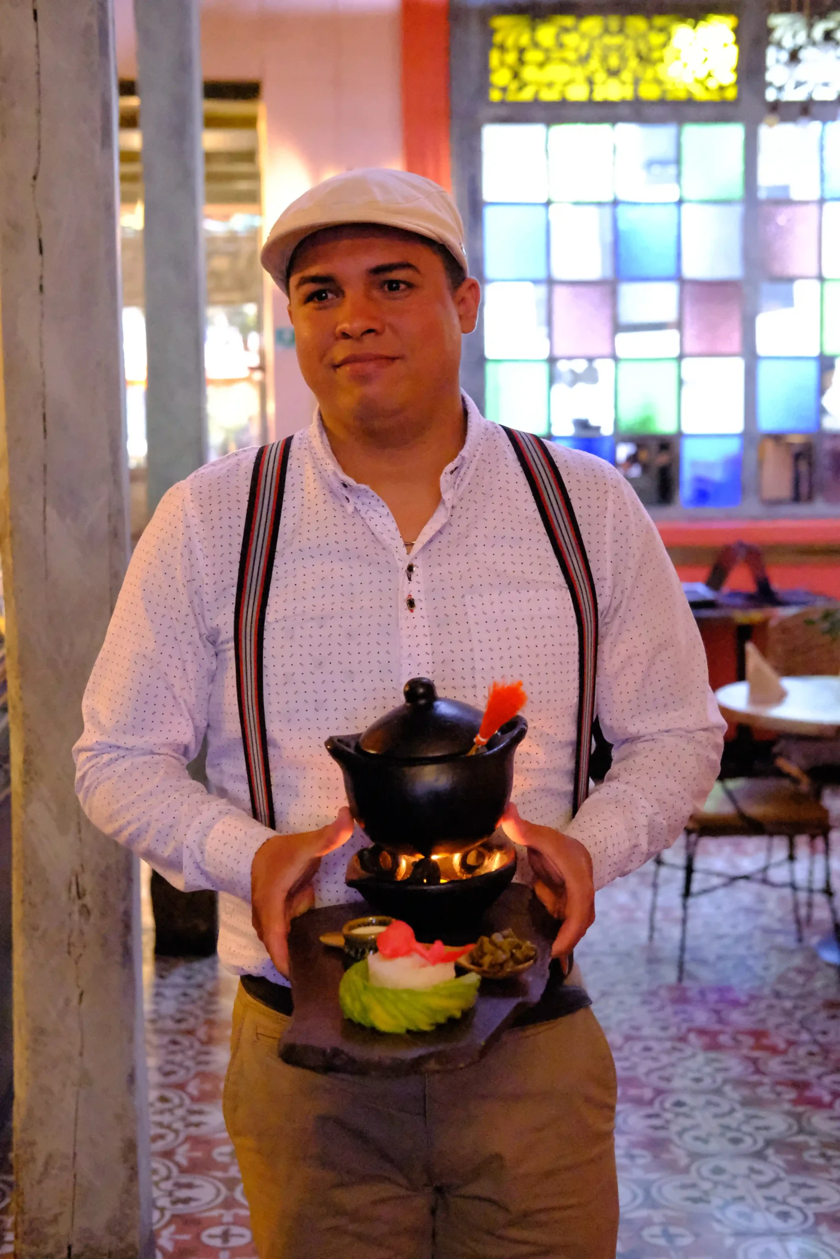 Man presenting a traditional Ajiaco dish during a cooking class in Bogotá.