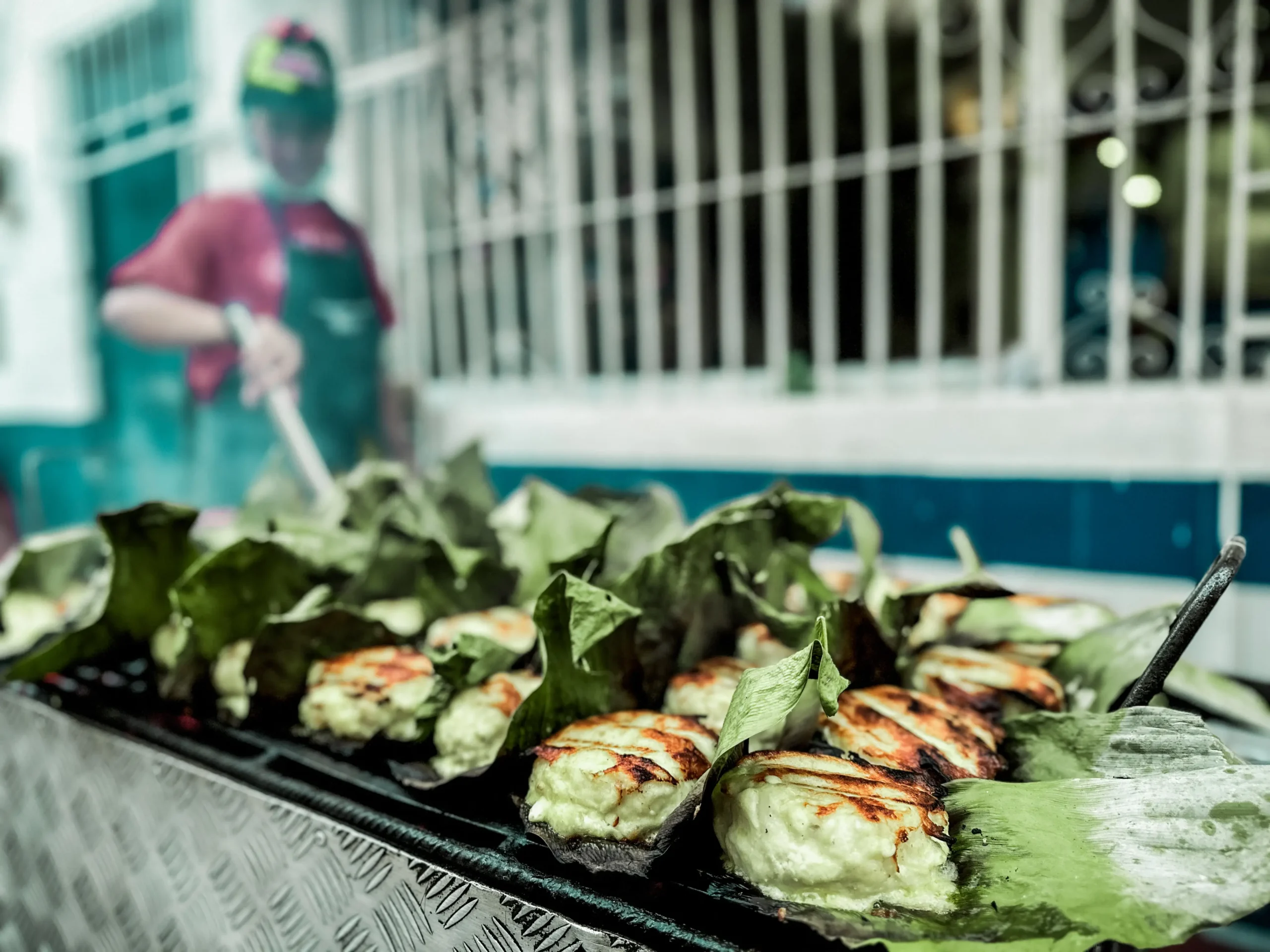 Grilled cheese-filled arepas served on leaves during Santa Marta food tour, showcasing local street food specialties