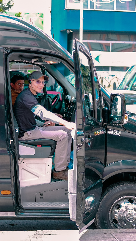 A tour guide sitting in a black van, ready to start a private transportation tour to the Salt Cathedral from Bogotá.