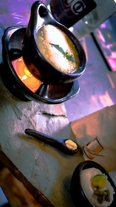 Ajiaco soup served in a traditional pot with garnishes during a Bogotá cooking class.