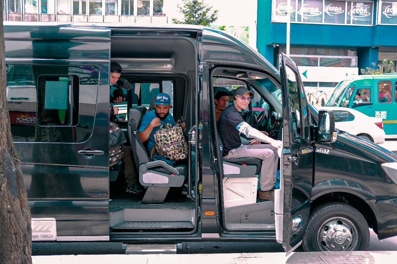 Tour guide and passengers in a black van, ready for a private transportation tour to the Salt Cathedral from Bogotá.